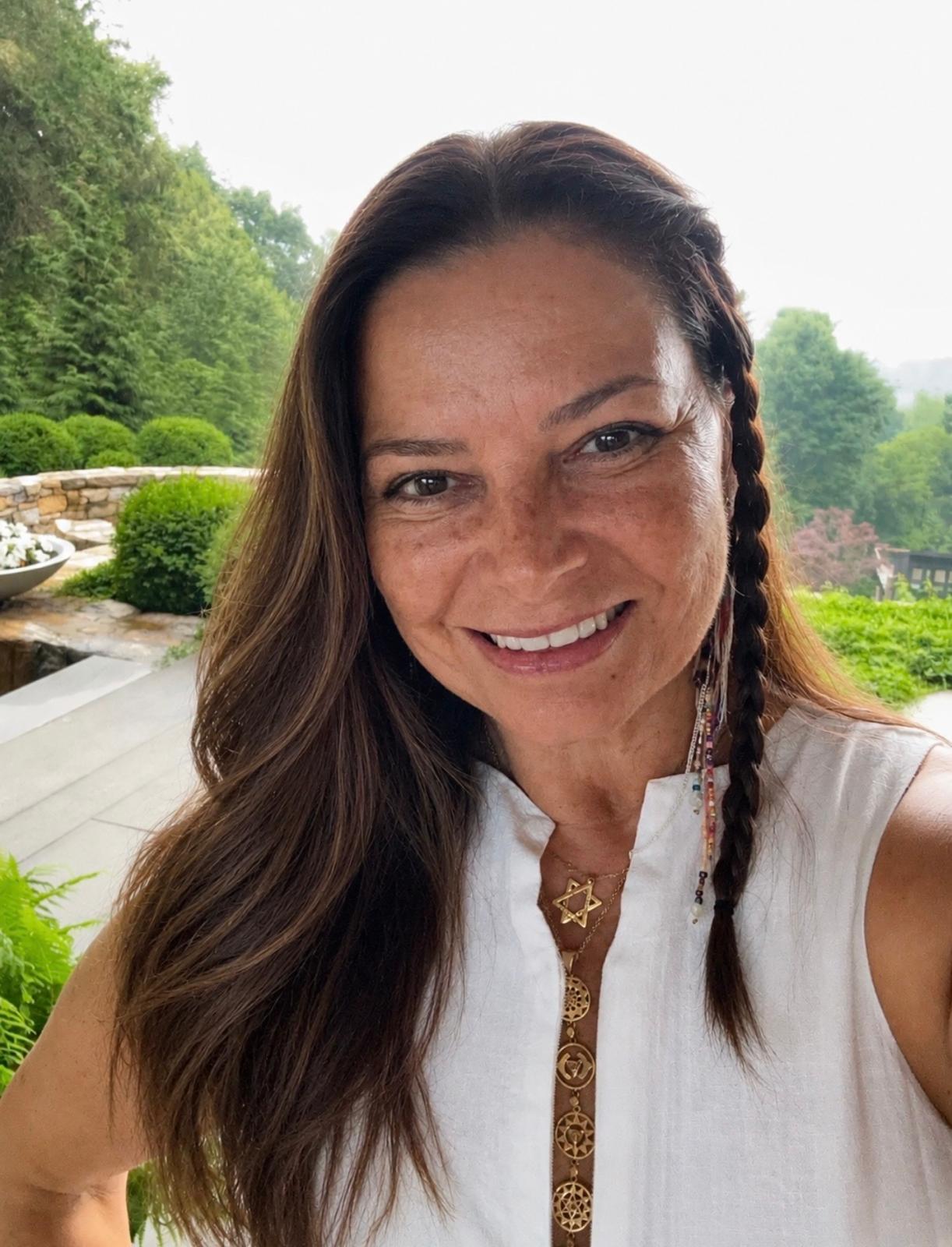 Alexandra Defacio, terapeuta holística, sorrindo ao ar livre